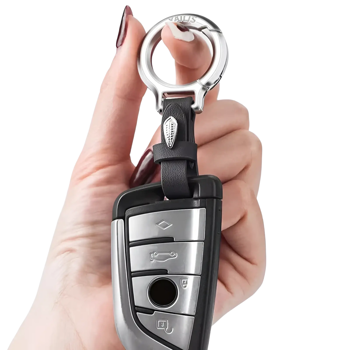 Black leather car keychain with silver metal ring and decorative leaf charm attached to a BMW key fob