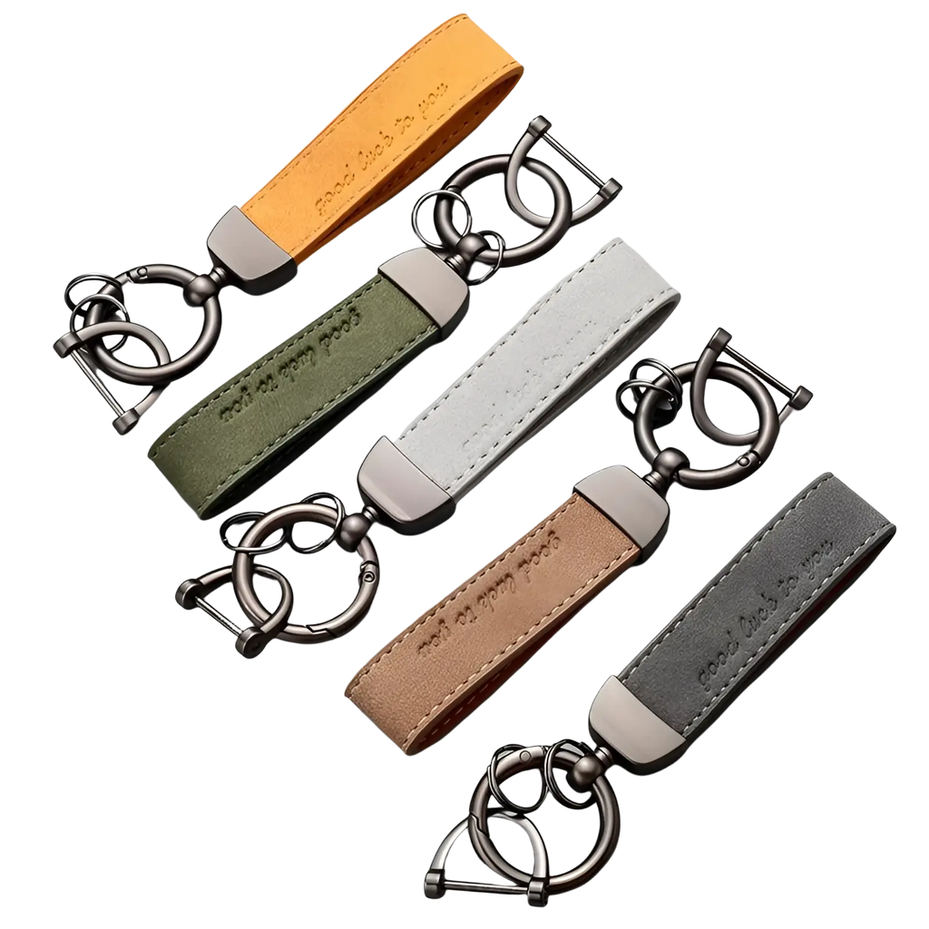 Set of four leather car keychains in orange, olive green, beige, and gray with brushed metal hardware