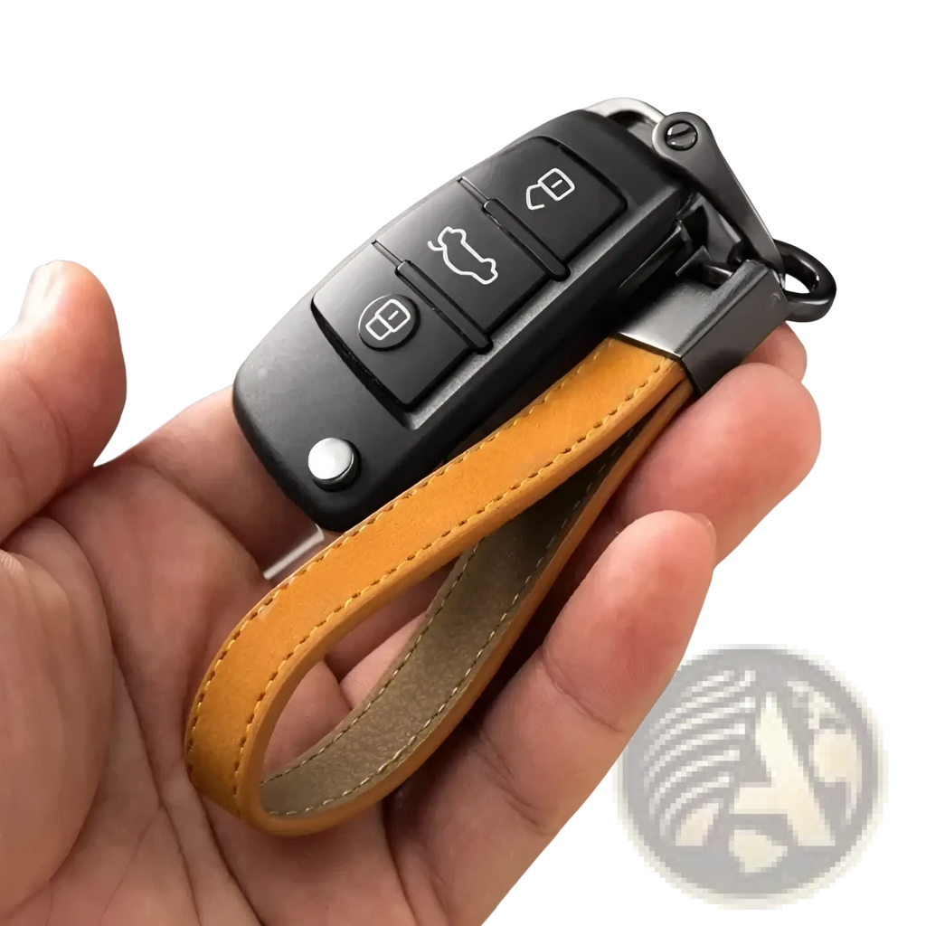 Black audi key fob attached to a tan leather strap of a minimalist leather car keychain key ring