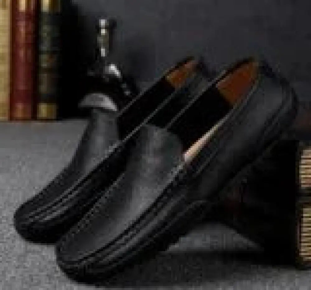 Men’s soft leather slip on loafers in black with classic slip-on design and contrasting tan lining for casual wear