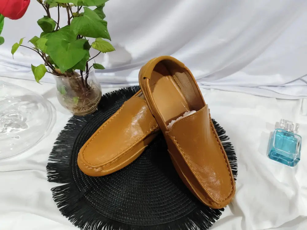 Men’s soft leather slip-on loafers in tan with a smooth glossy finish and visible stitching for casual wear
