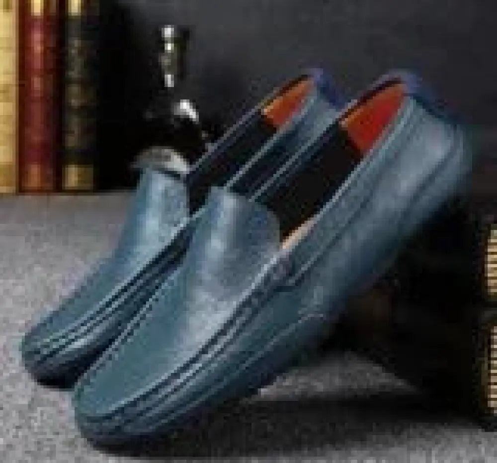 Men’s soft leather slip on loafers in dark blue with sleek minimalist design and contrasting orange lining
