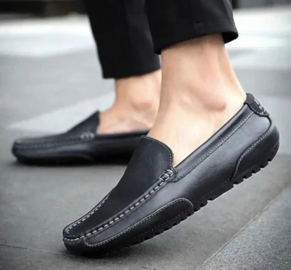 Men’s soft leather slip on loafers in black with contrasting white stitching and textured rubber sole for casual wear
