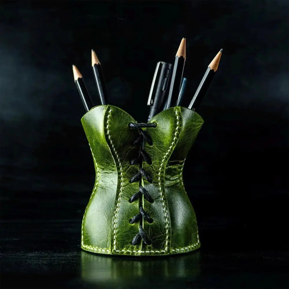Handcrafted green leather corset desk organizer with black lacing and stitching used as a pen holder