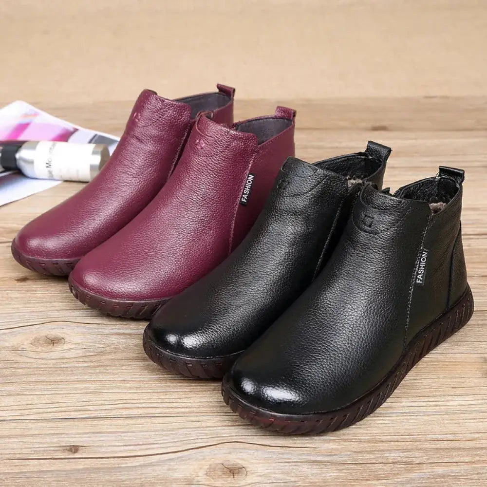 A pair of black and burgundy non-slip leather warm cotton ankle boots with textured surface and fashion branding