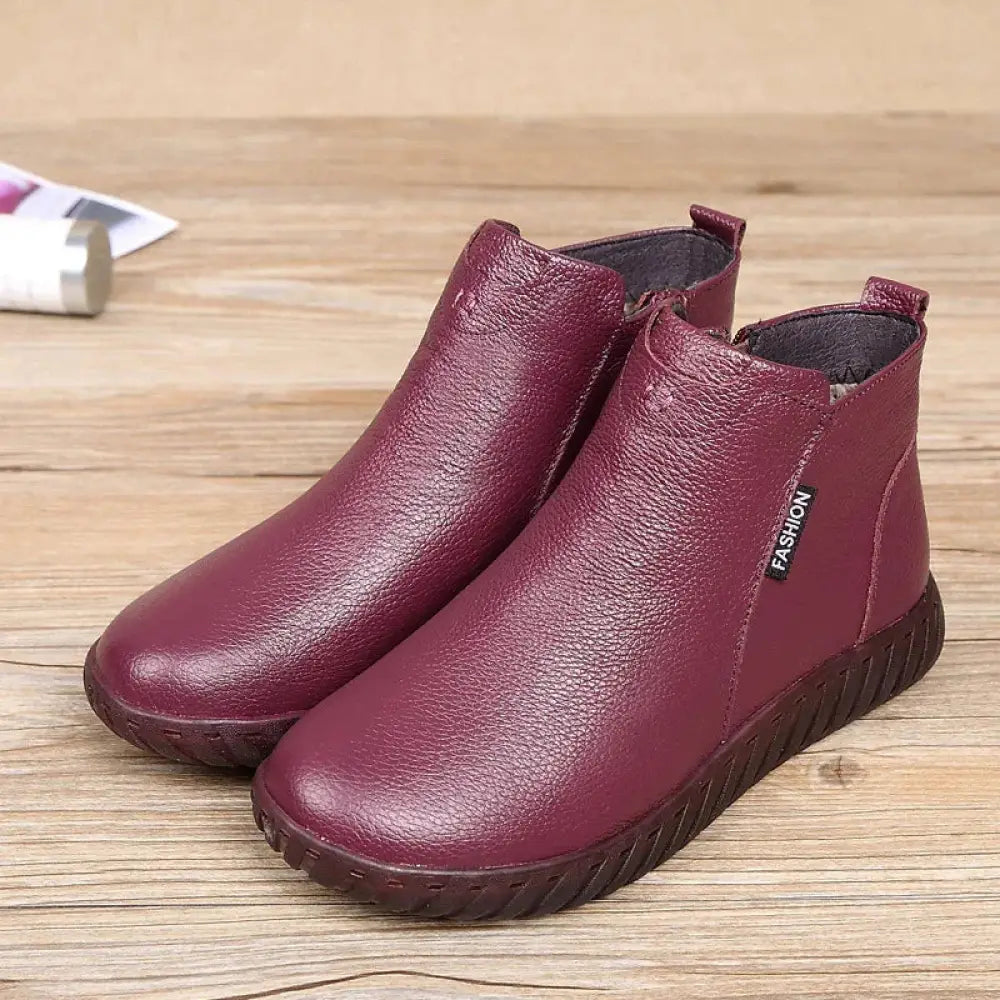 Maroon leather women’s non-slip ankle boots with textured surface and dark brown rubber soles for warmth and comfort