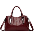 Burgundy leather crossbody handbag with silver-tone accents and kangaroo logo emblem featuring pocket interior