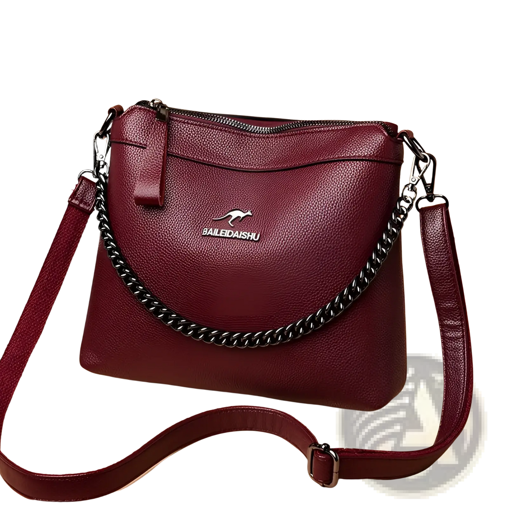 Leather crossbody handbag in burgundy leather with silver chain strap and kangaroo logo plaque on the front