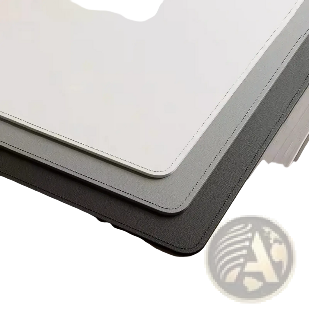 Stacked minimalist leather desk pad protectors in cream gray and black faux leather with stitched edges for office use