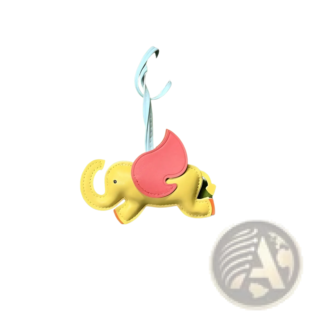 Leather elephant bag charm featuring a cheerful yellow elephant with pink wings made from soft leather attached to a light blue strap