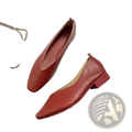 A pair of elegant red leather flat shoes for women with a pointed toe and low block heel slip on design