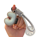 Light blue leather initial keychain with stitched letter j and silver-toned rope strap wristband charm
