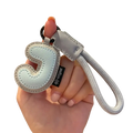 Light blue leather initial keychain with stitched letter j and silver-toned rope strap wristband charm