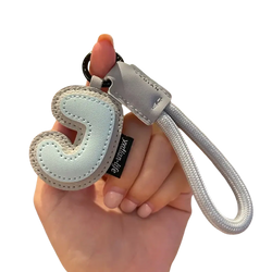 Light blue leather initial keychain with stitched letter j and silver-toned rope strap wristband charm