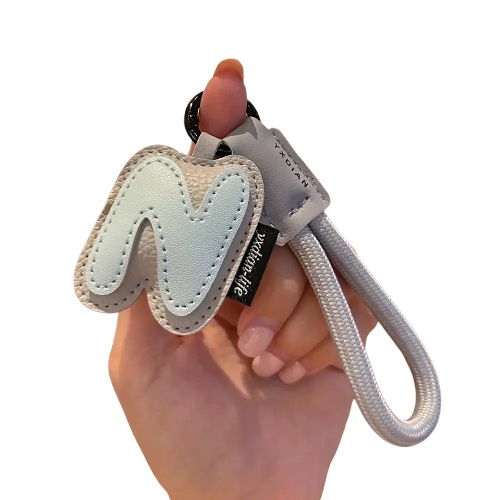 A light blue leather initial keychain with stitched letter m and gray braided strap featuring a black metal ring
