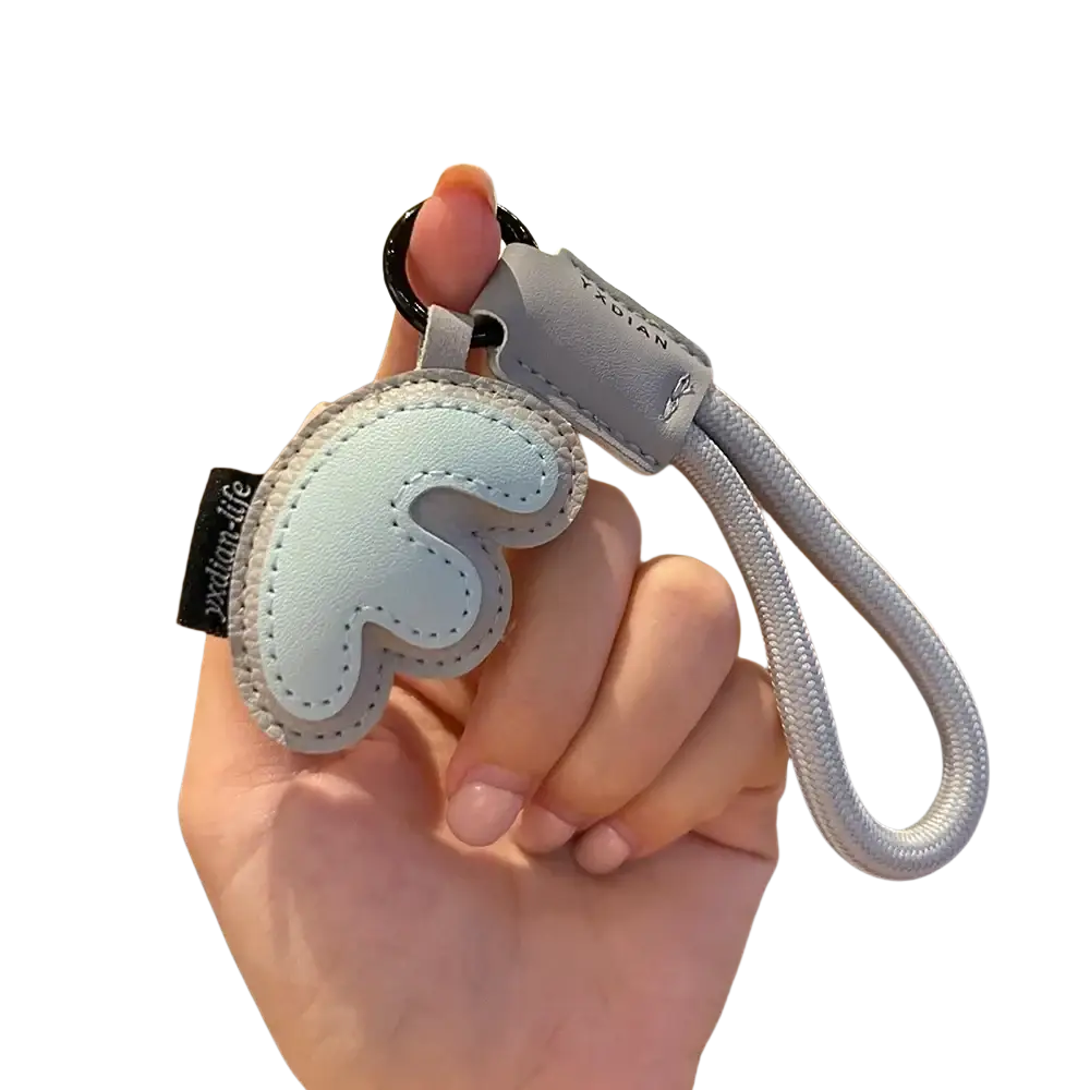 Light blue leather wing-shaped keychain with gray stitching and braided strap for initial letter wristband charm