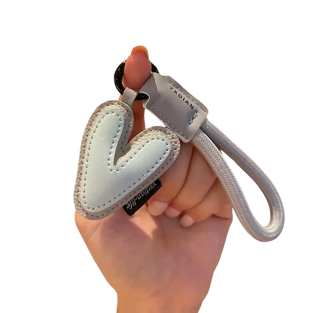 A light blue leather heart-shaped initial keychain with stitched edges and gray fabric wristband by yxdian