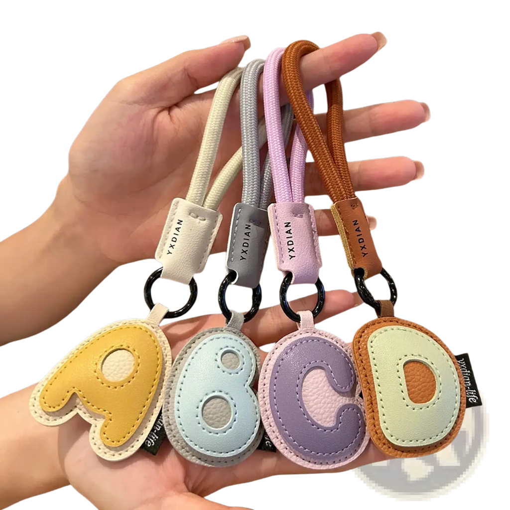 Pastel-colored leather initial keychain letter wristband charms with stitched leather-like material and braided straps