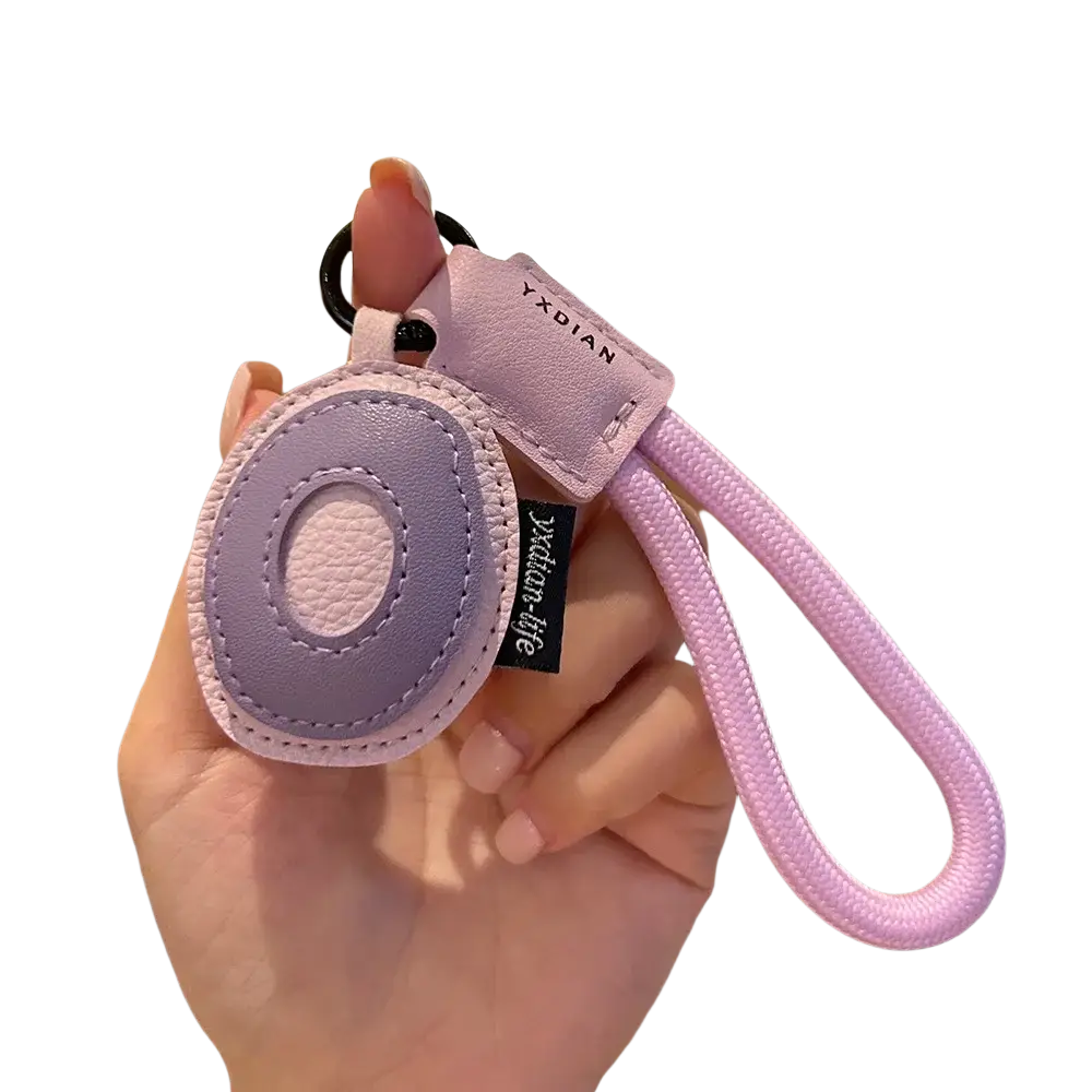 A soft lavender leather initial keychain letter o with braided strap and small tag wristband charm
