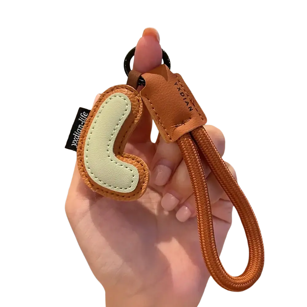 Leather initial keychain letter wristband charm in tan leather with light green stitched phone charm and orange braided strap