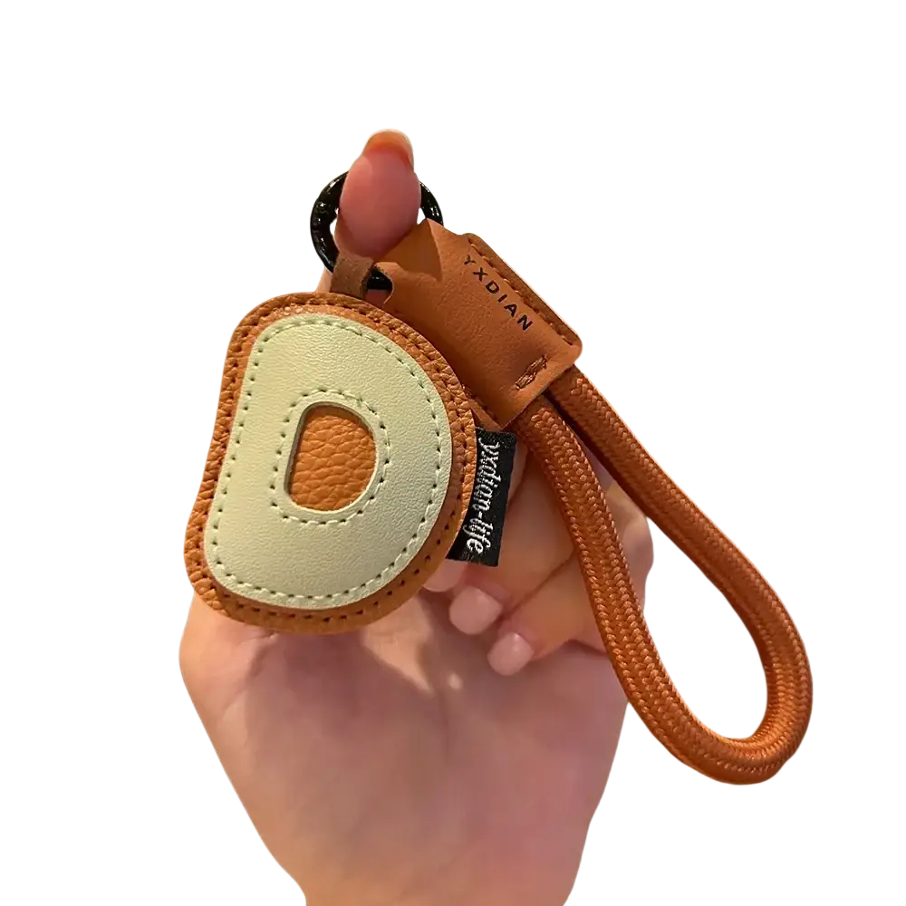 A tan leather initial keychain letter wristband charm with a cream stitched letter d and braided cord