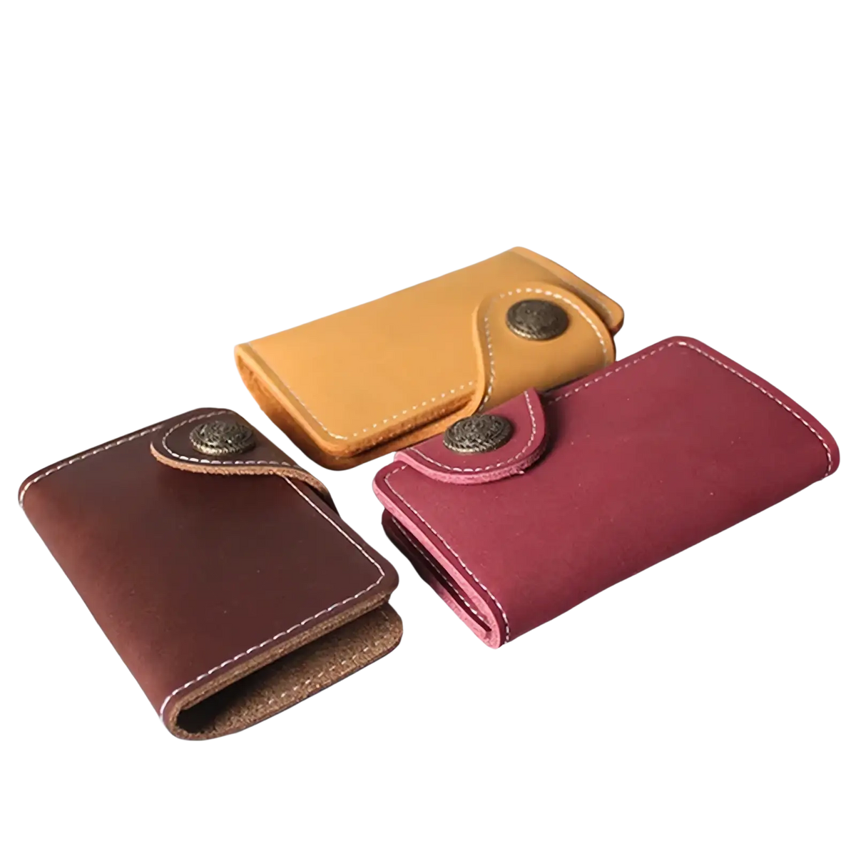 Three compact leather key pouch wallets with card holders in brown maroon and tan hues with vintage metal clasps