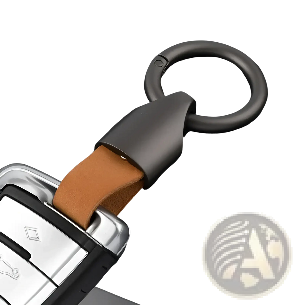 Dark gray metal leather keychain with tan leather strap attached to a car key fob for bag charm use