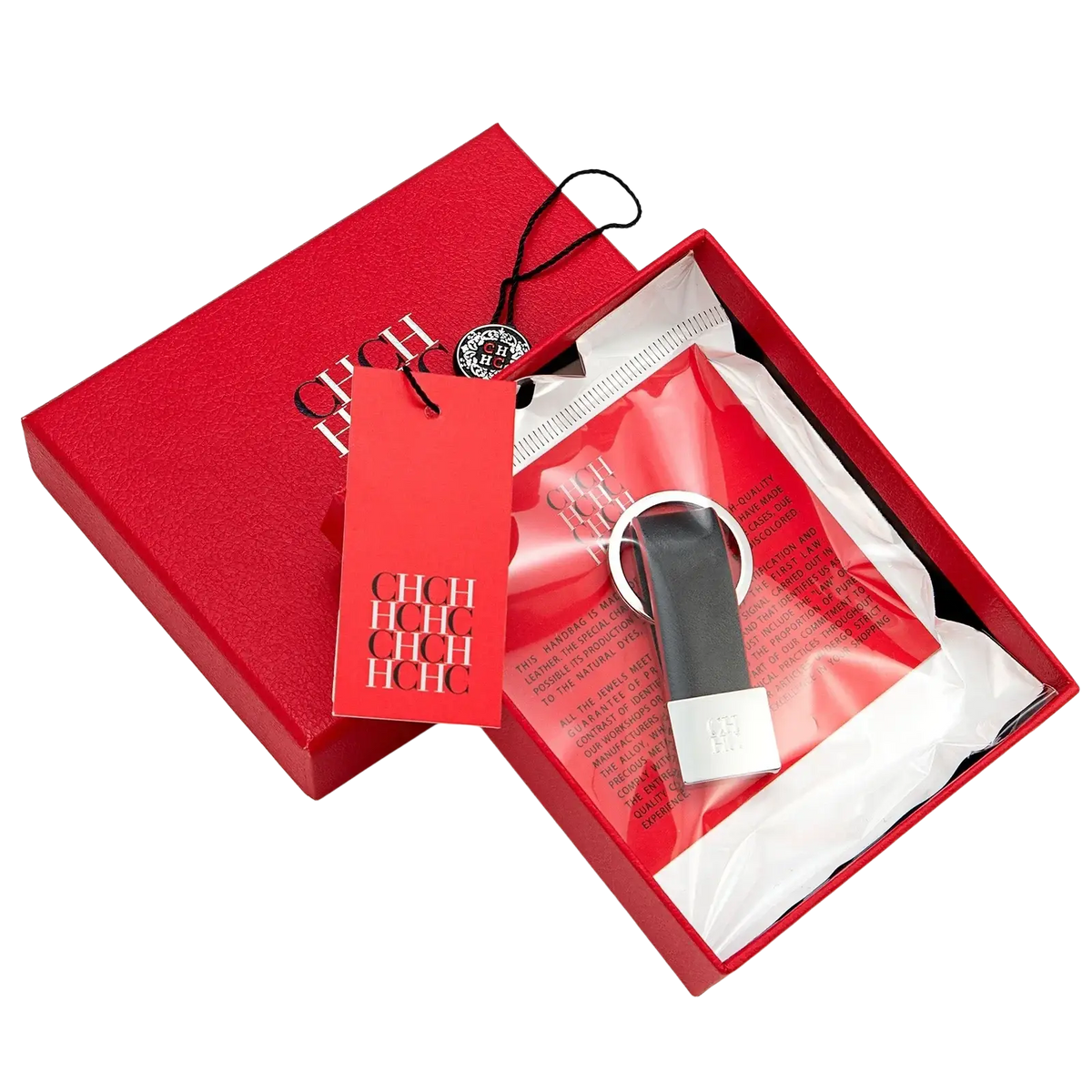 Black leather minimalist luggage keychain with silver metal ring and plate in a red hch branded box