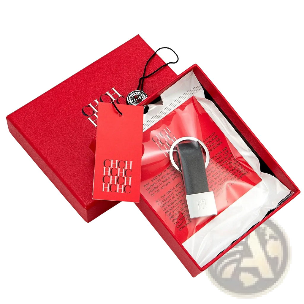 Black leather minimalist luggage keychain with silver metal ring and plate in a red hch branded box