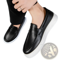 Black leather slip-on loafers with white rubber soles and stitched detailing for comfortable casual wear