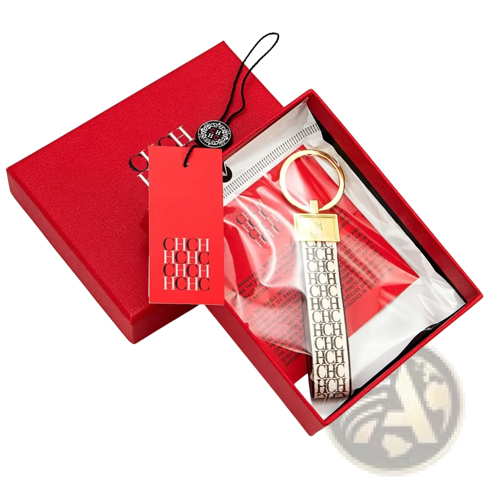 Gold-toned leather logo keychain with black and white ch strap in a red branded box for designer fashion accessory gift