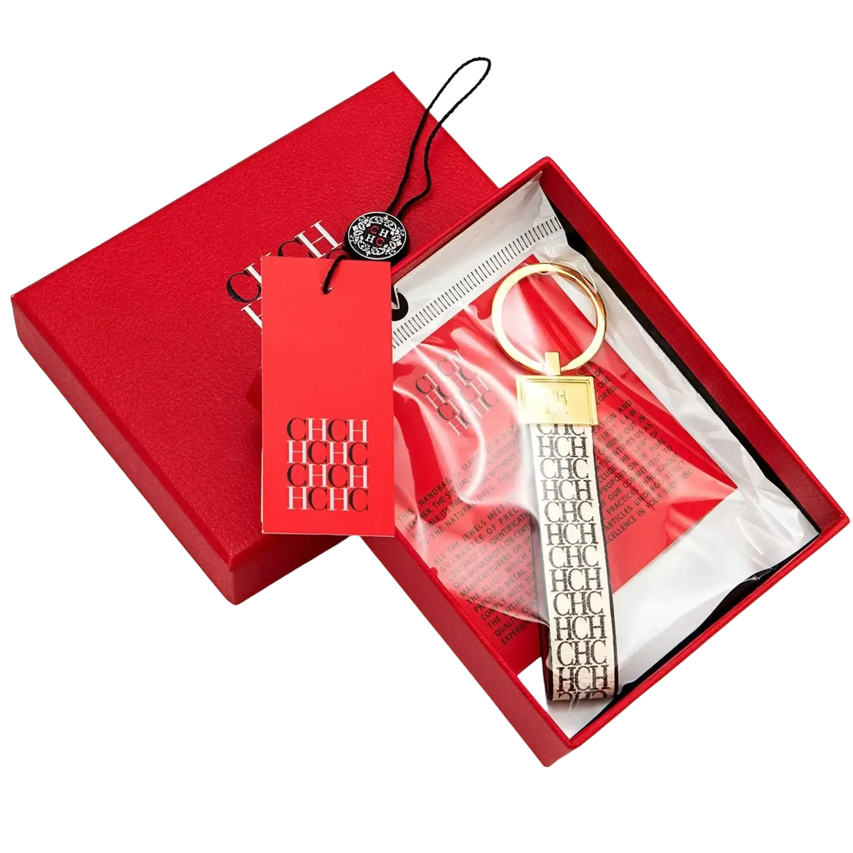 Gold-toned leather logo keychain with black and white ch strap in a red branded box for designer fashion accessory gift