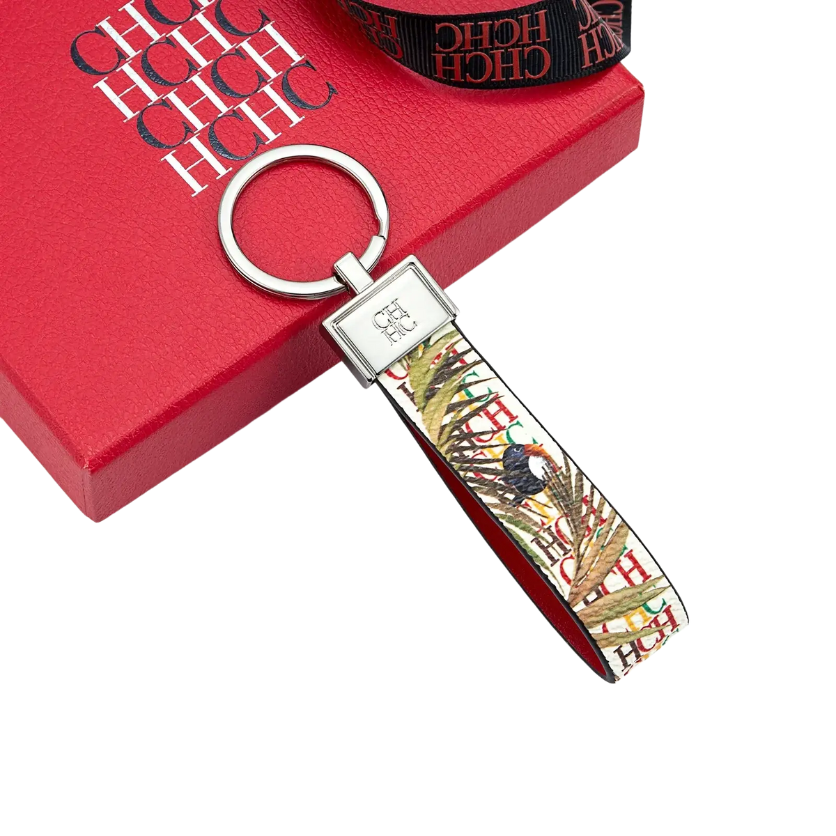 Leather logo keychain with silver metal ring and vibrant tropical fabric strap featuring palm leaves and birds