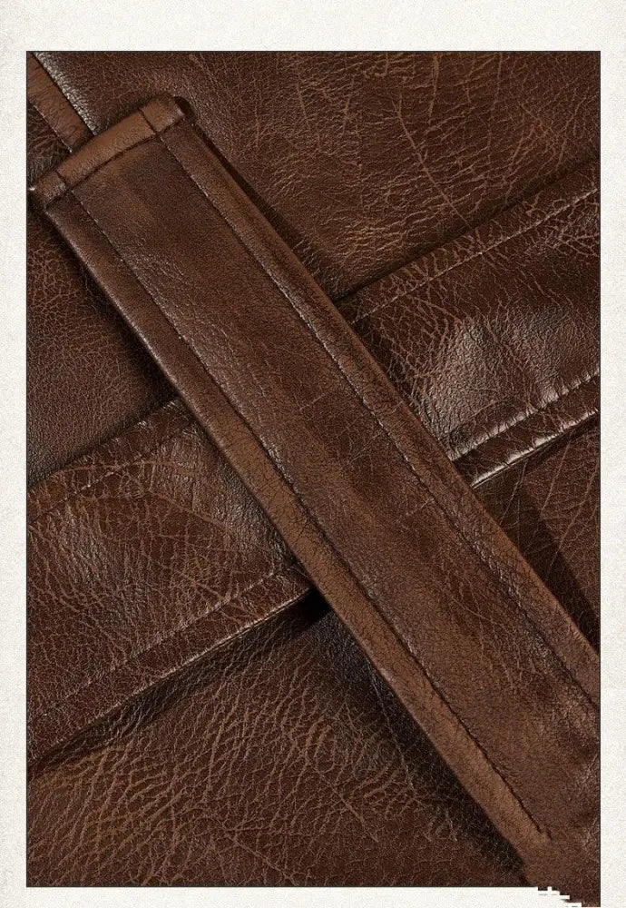 Brown faux leather strap with visible stitching and textured cracked surface on unisex faux leather mid length trench coat