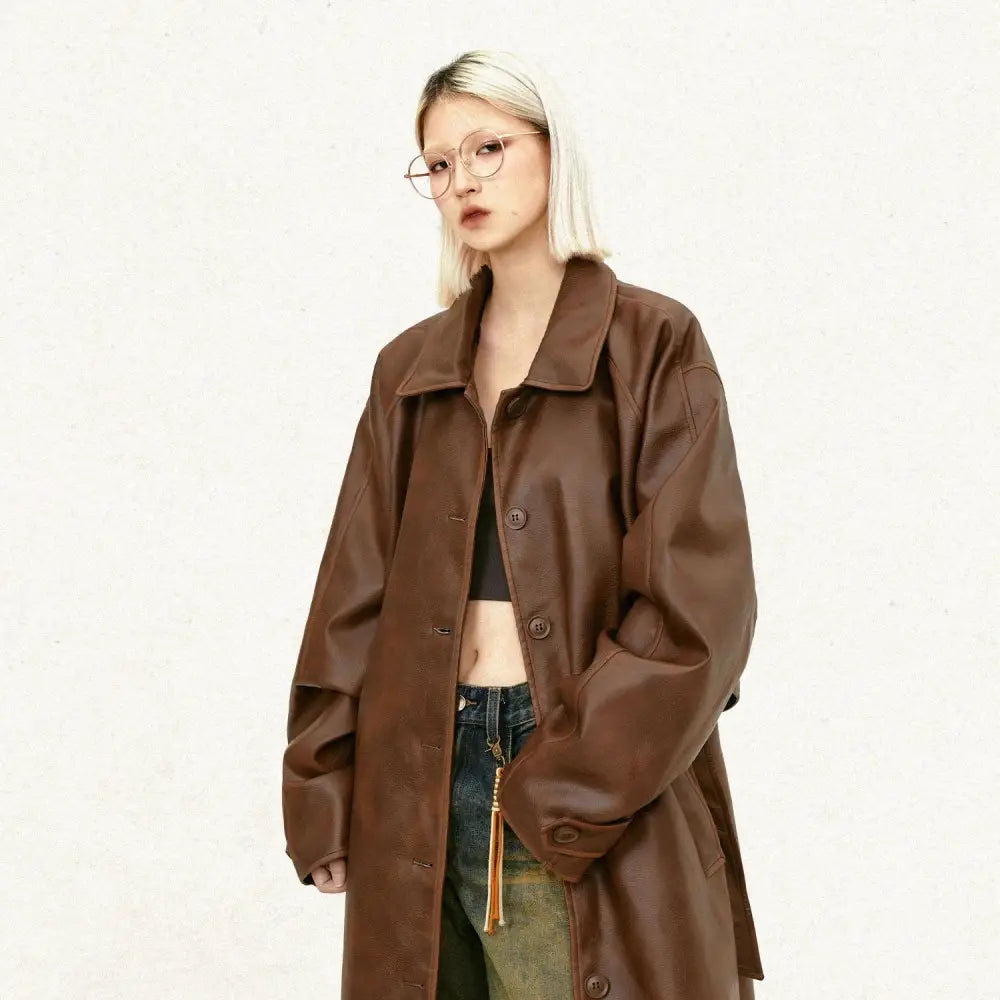 Brown unisex faux leather mid length trench coat with classic collar and button closure front view