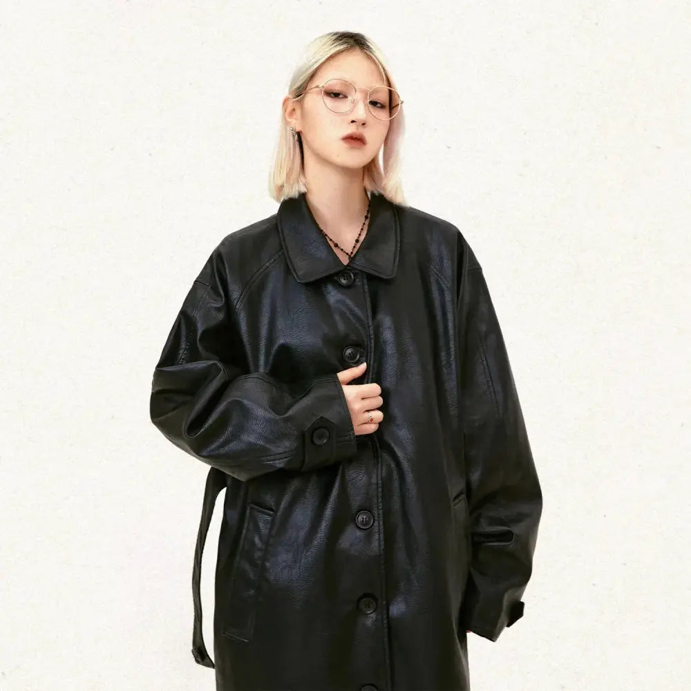 Black faux leather unisex mid length trench coat with belted waist and button closures displayed from the back side