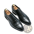Black leather oxford shoes with polished finish and decorative brogue detailing for men’s business casual wear
