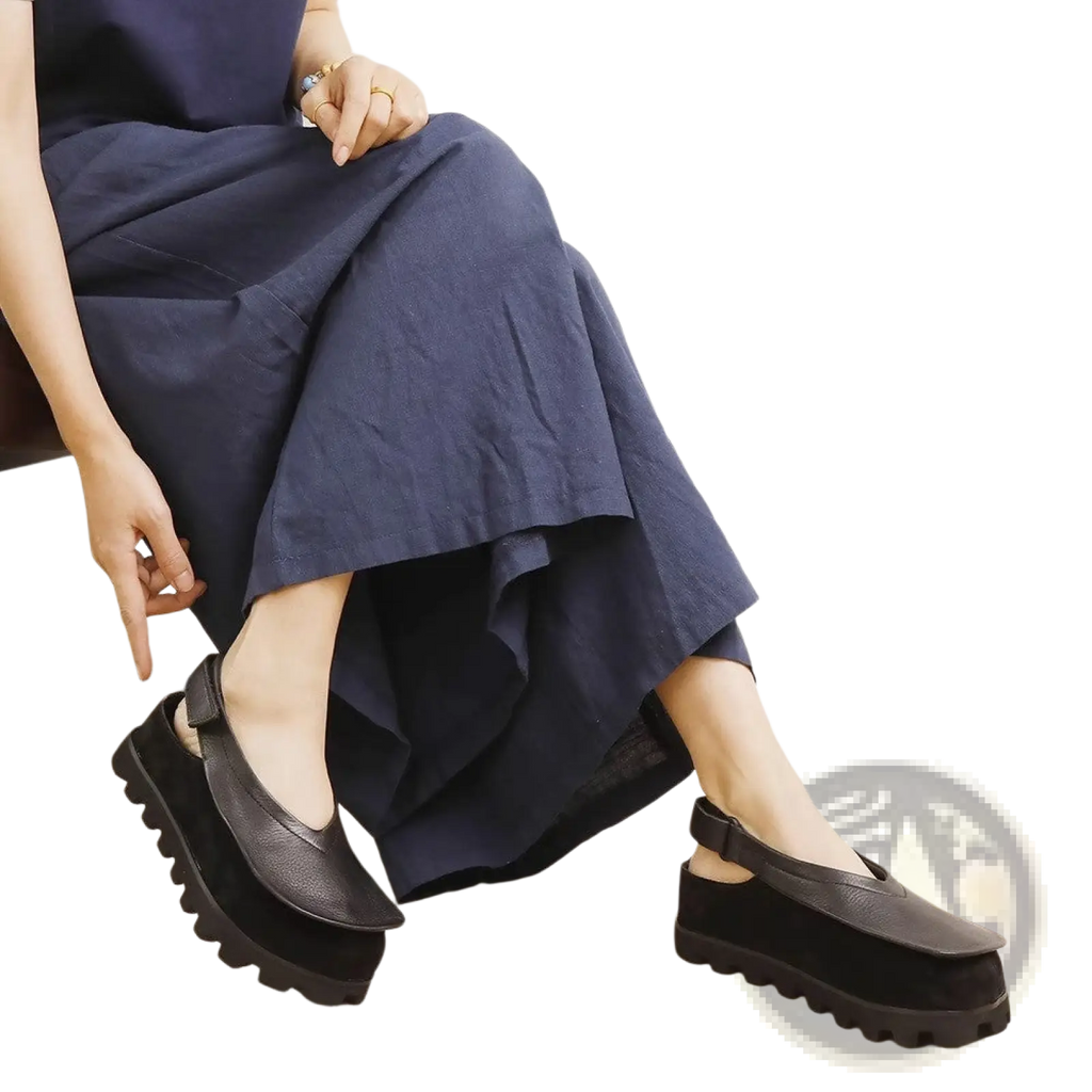 Black leather platform sandals with chunky textured sole and ankle strap in a retro open toe design