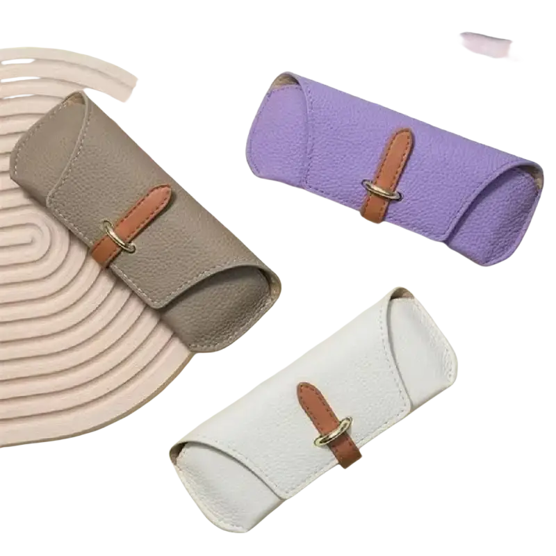 Beige leather reading glasses bag with tan strap and gold-tone buckle designed as a soft shell eyewear case