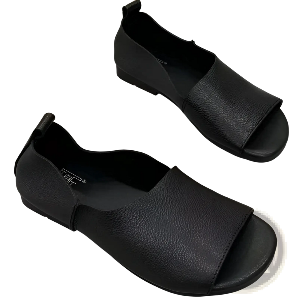 Black leather sandals with textured soft sole, peep toe, slip-on design, low heel, and elastic side strap