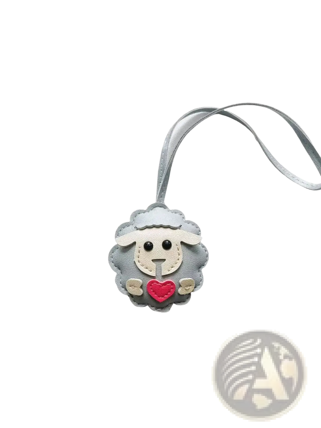 Gray leather sheep keychain with red heart and white face details attached to a matching gray ribbon bag charm