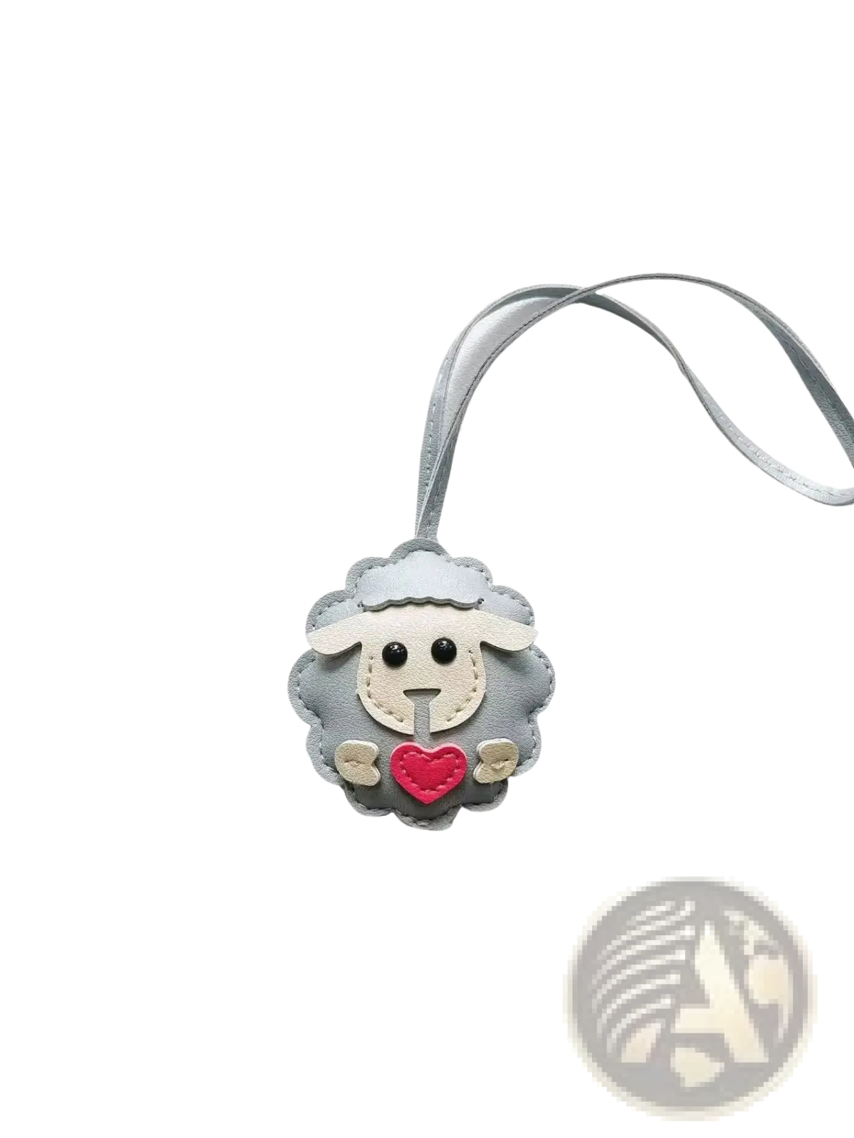 Gray leather sheep keychain with red heart and white face details attached to a matching gray ribbon bag charm