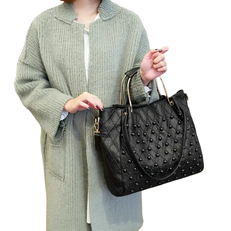 Black leather shoulder bag with studded quilted design gold-tone handles and visible pocket interior