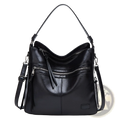 Black leather shoulder bag with curved top handle, adjustable strap, and multiple zippers for secure crossbody use
