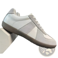 A minimalist gray and white leather sneakers with suede upper and chunky sole for versatile casual wear