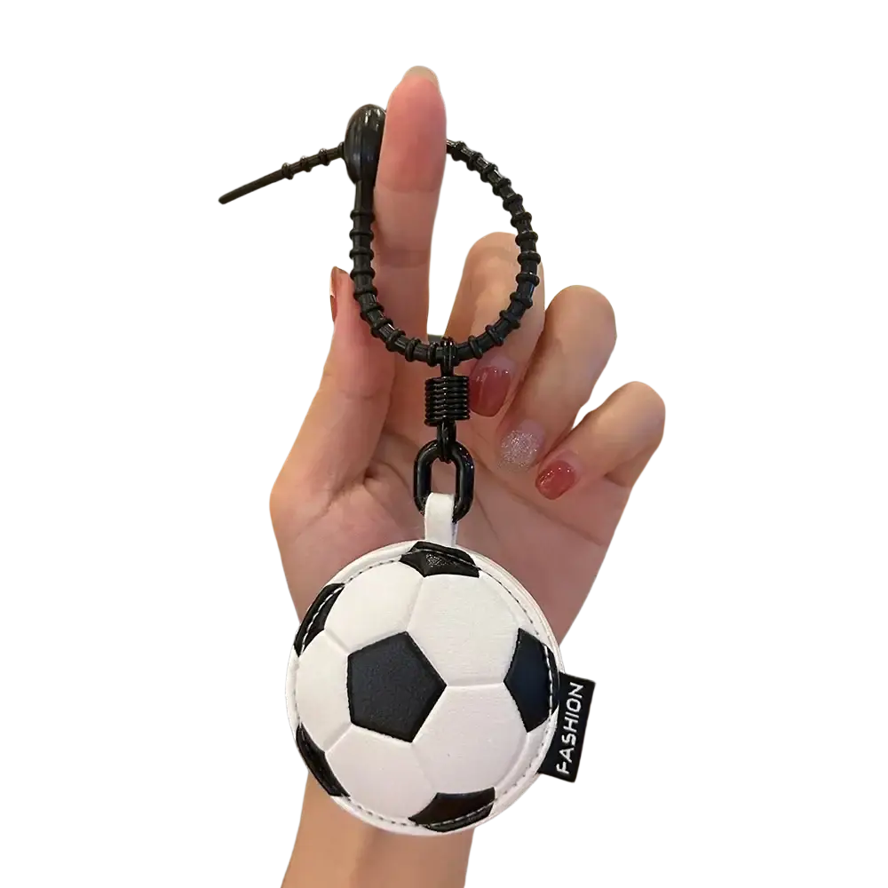 Black and white leather sports ball keychain with a textured surface used as a bag charm accessory