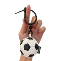 Black and white leather sports ball keychain with a textured surface used as a bag charm accessory