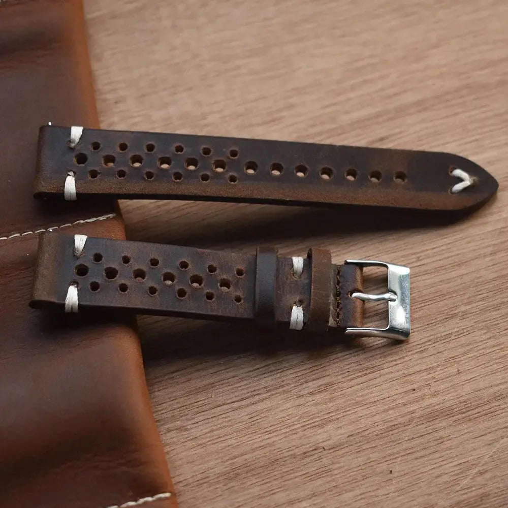 Handmade perforated crazy horse leather strap in dark brown with silver buckle and white stitching for accessories