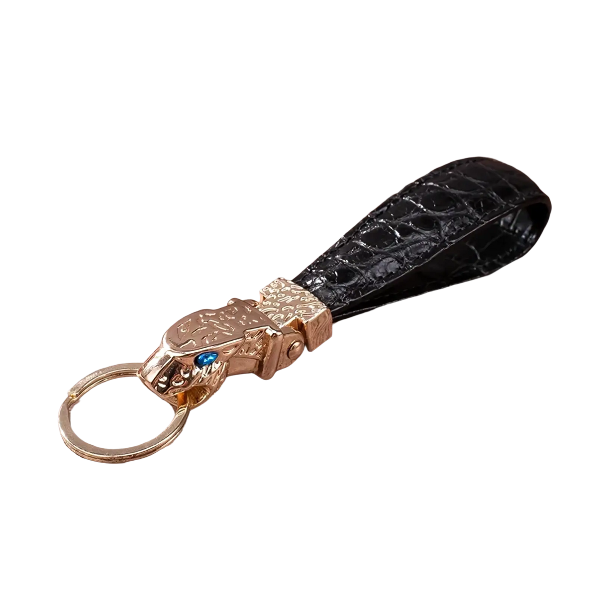 Black crocodile leather luxury keychain with gold-toned tiger head charm featuring a blue gemstone for car keys