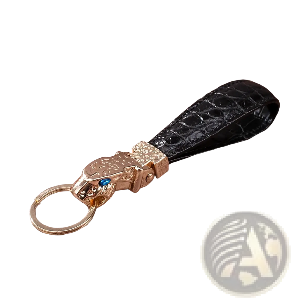Black crocodile leather luxury keychain with gold-toned tiger head charm featuring a blue gemstone for car keys